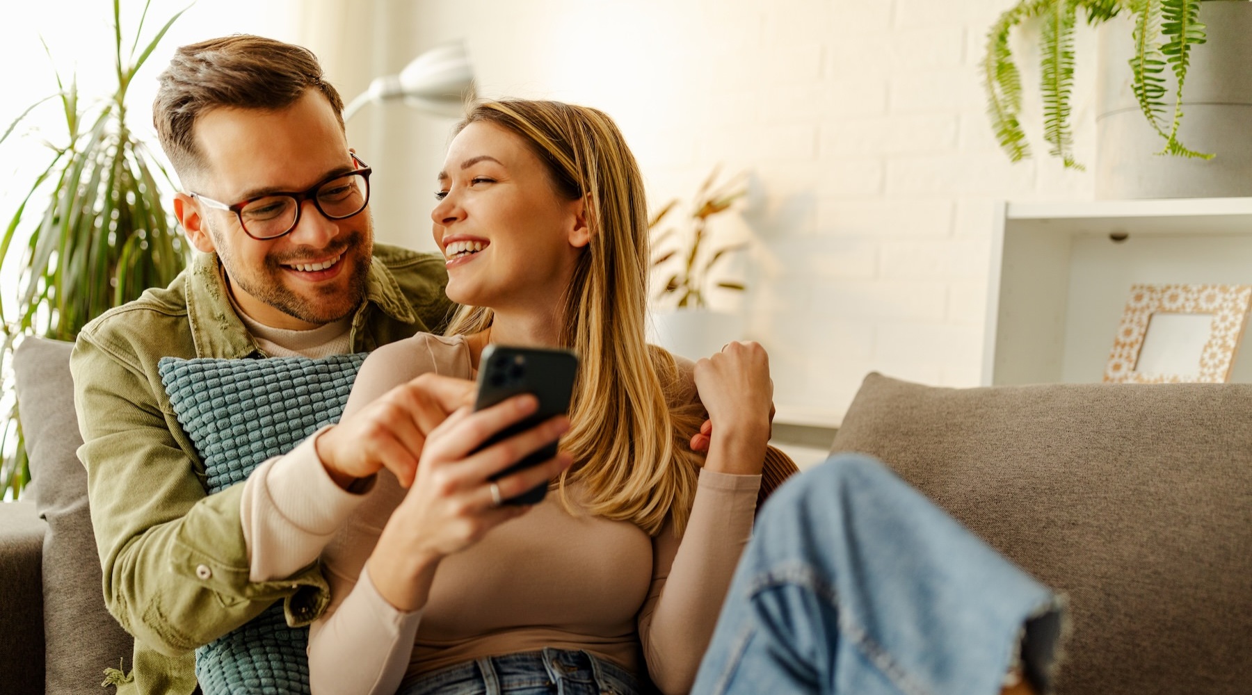 a couple with a phone on a couch